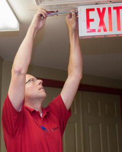 Man inspecting emergency exit sign